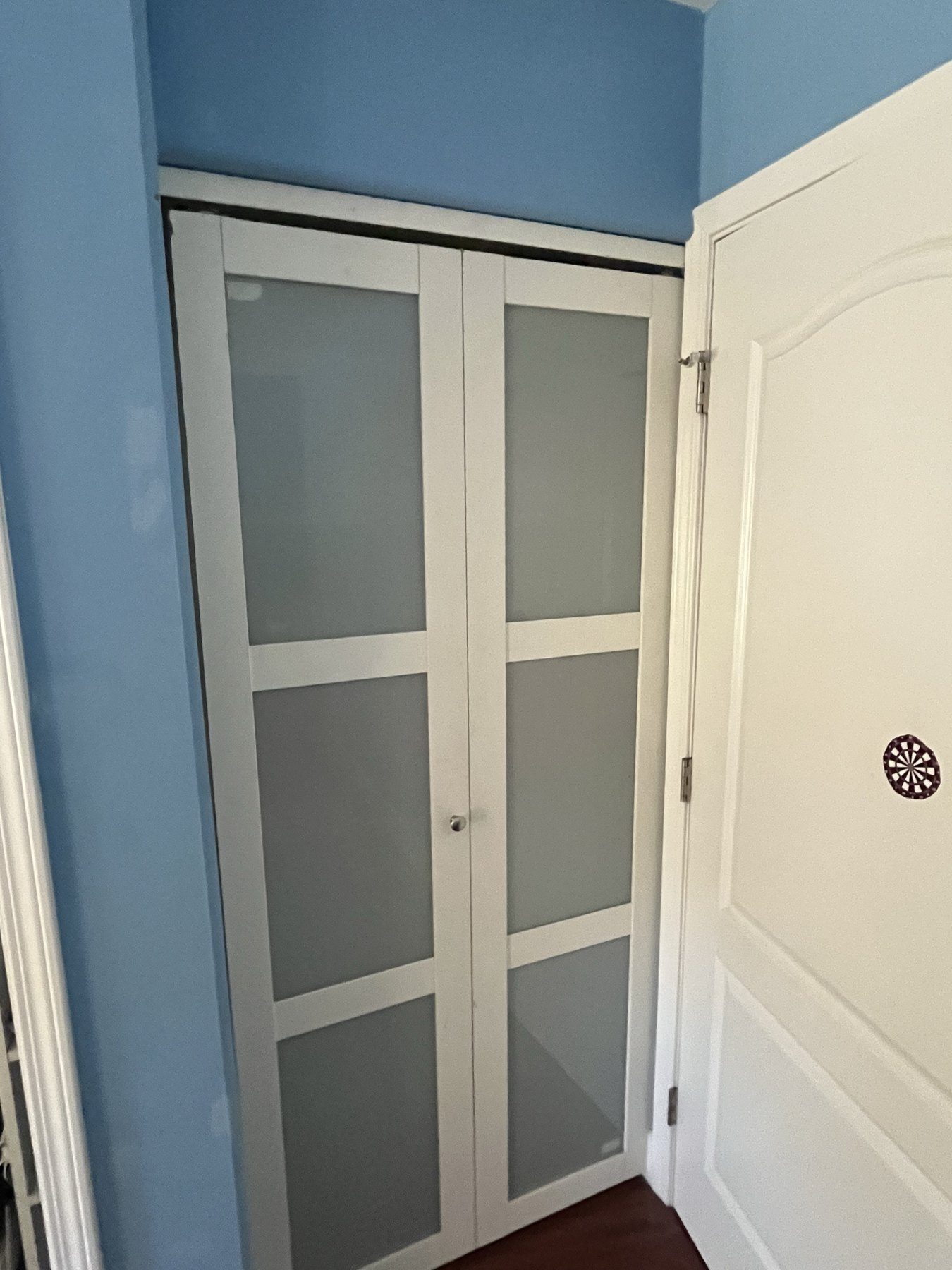 Frosted glass bi-fold closet doors installed in a hallway
