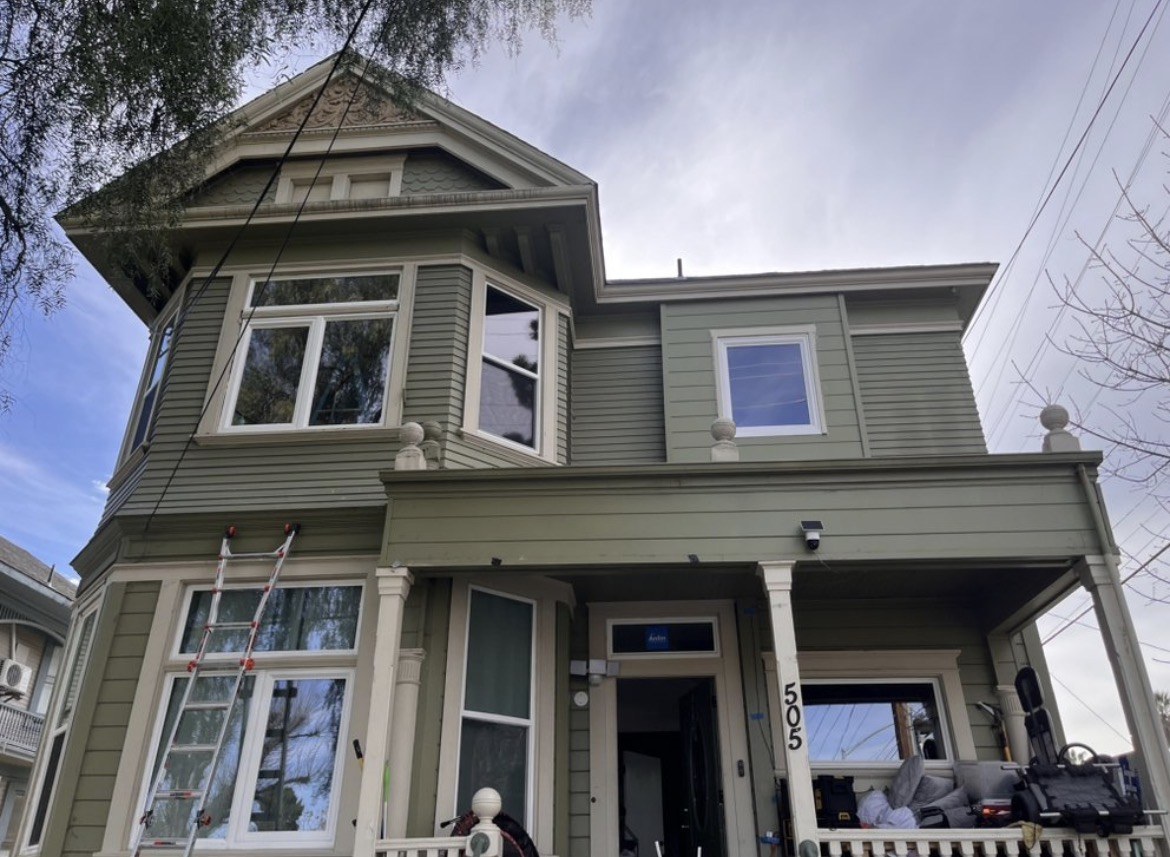 Freshly painted green Victorian home exterior