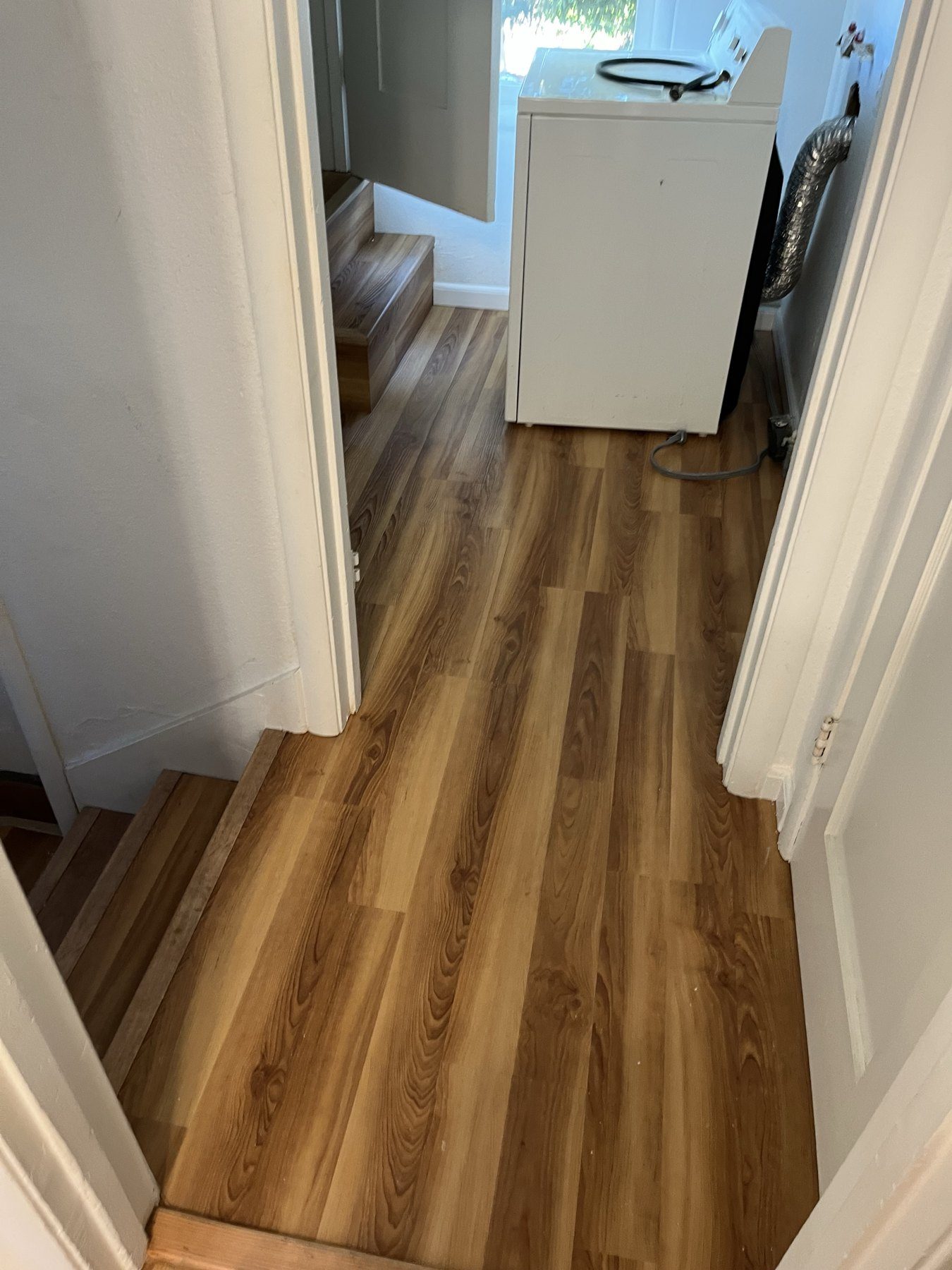 Vinyl plank flooring with step-down transition into a laundry area