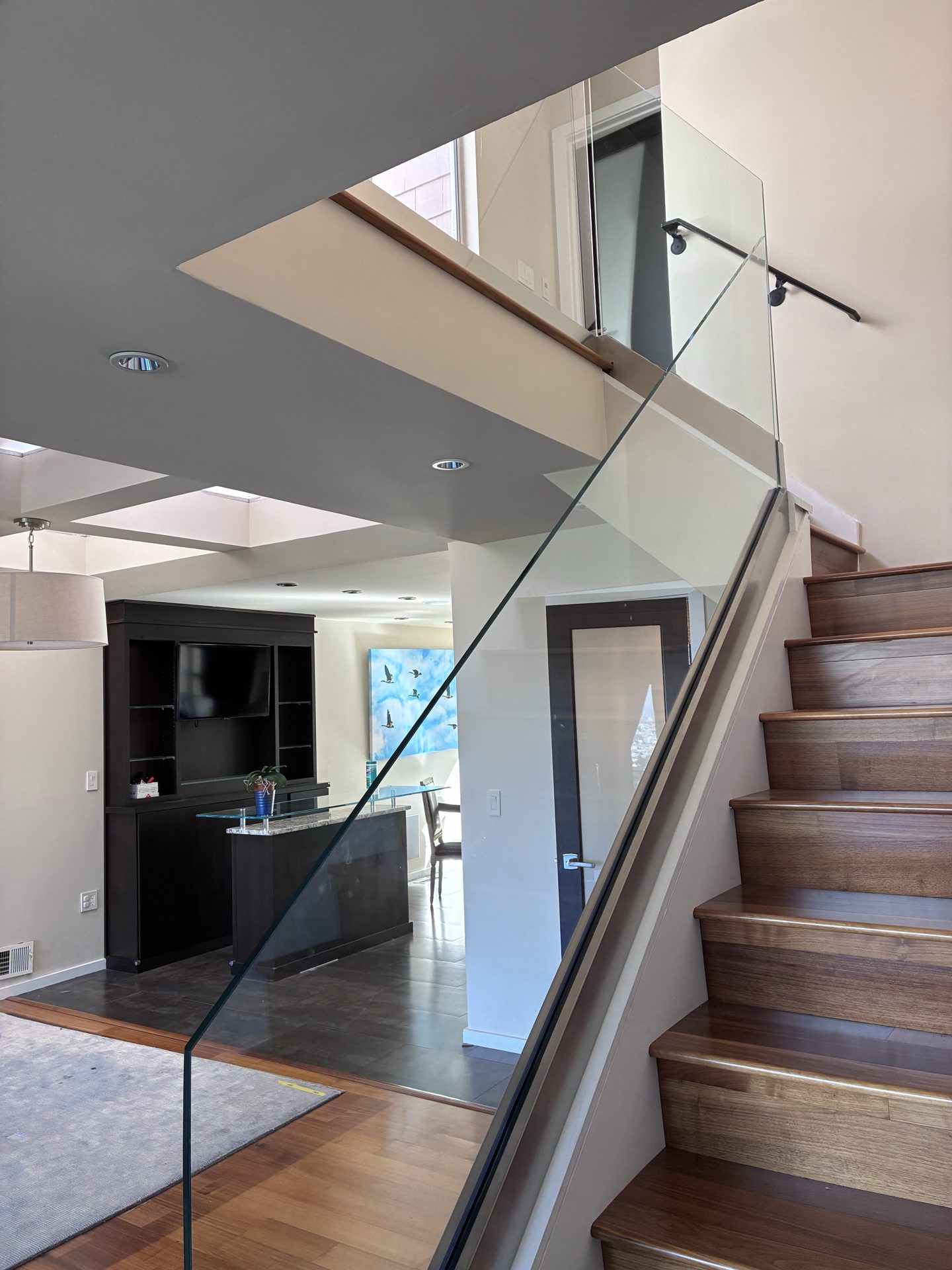 Modern glass stair railing with slim metal posts